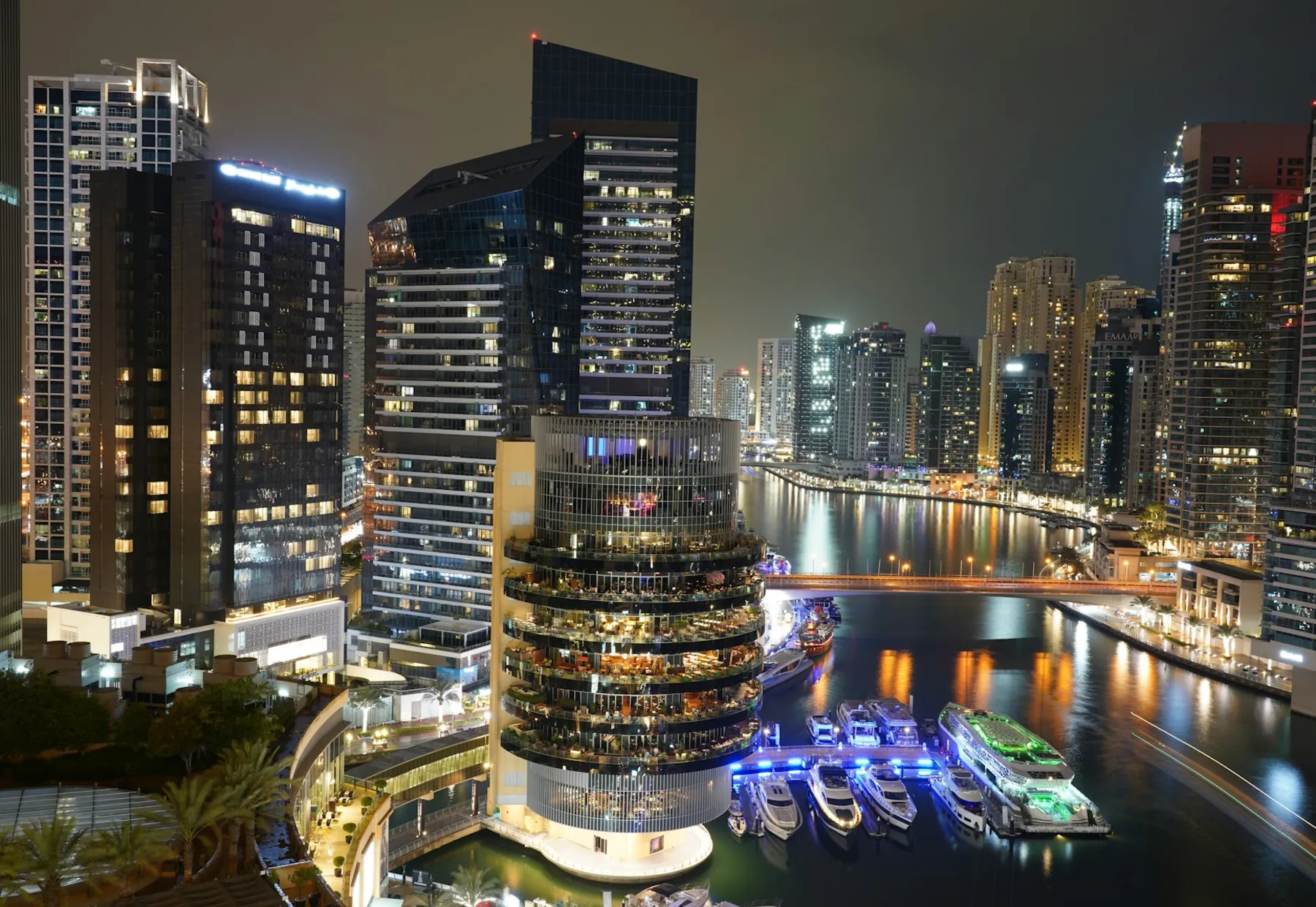 Illuminated waterfront towers and residential buildings around Dubai Marina at night