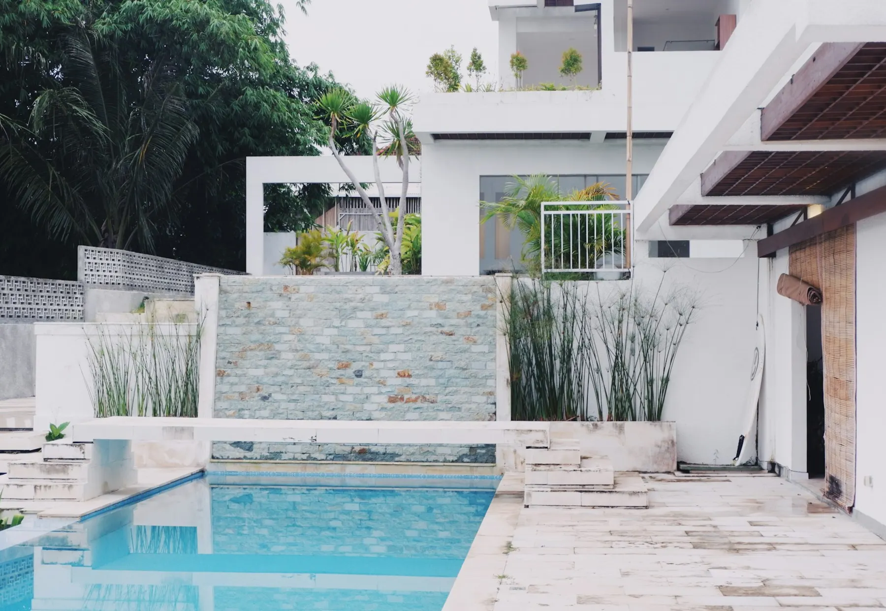 White contemporary residence with an outdoor swimming pool and planted courtyard
